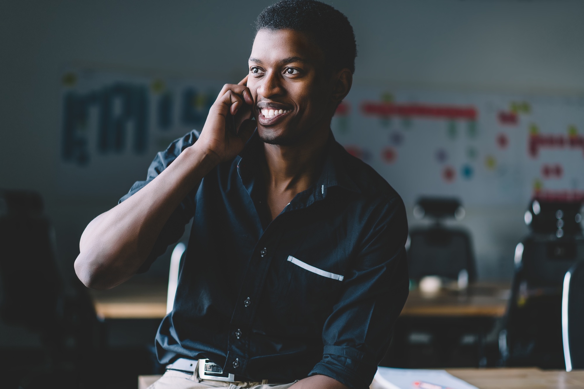 African American office worker in formal wear calling on smartphone and smiling