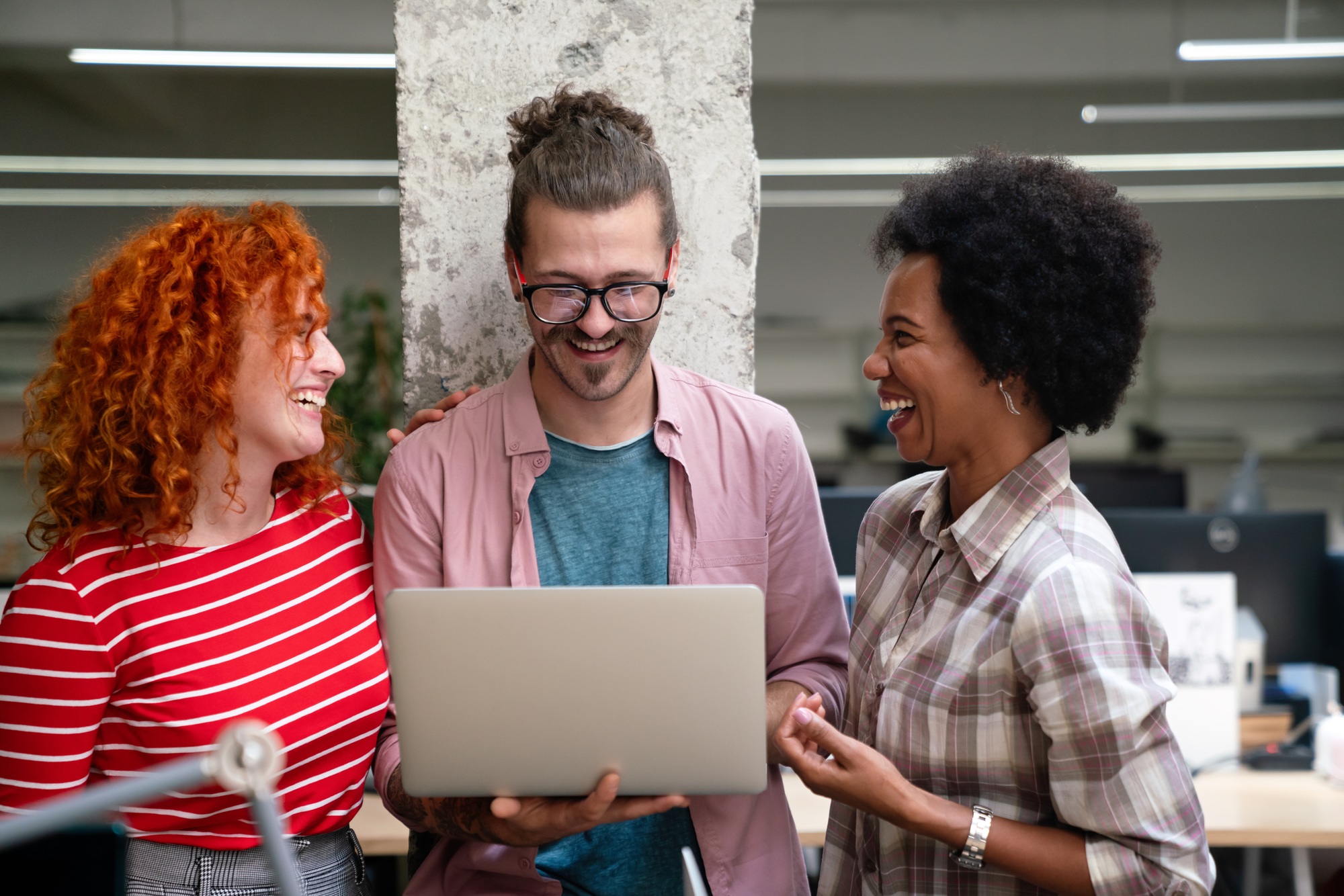 Diverse group of professionals meeting in office. IT programmers use computer, talk strategy